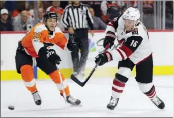  ?? CHRIS SZAGOLA — THE ASSOCIATED PRESS ?? Arizona’s Max Domi, right, shoots the puck past the Flyers’ Taylor Leier, left, during the first period Monday. The Flyers roared back to get the game into overtime, but lost 4-3.