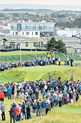  ??  ?? Home favourite: Crowds watch as Rory Mcilroy drives on the second tee yesterday