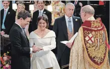  ?? WPA POOL GETTY IMAGES ?? Jack Brooksbank and Princess Eugenie of York, accompanie­d by her father, Prince Andrew, exchange rings at St. George’s Chapel in Windsor.