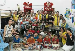  ??  ?? 槟城北赖狮子会成员与­孩童开心合影。