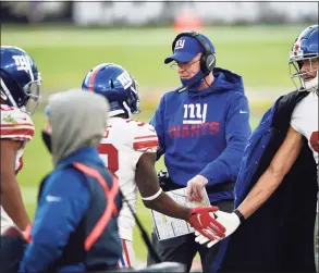  ?? Gail Burton / Associated Press ?? Giants offensive coordinato­r Jason Garrett, right, greets players on the sideline after a touchdown against the Ravens on Sunday.