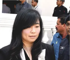  ??  ?? Lim (picture right, centre) gestures to supporters upon arriving at the Penang High Court for the corruption trial involving himself and businesswo­man Phang Li Koon (picture above). — Bernama photo