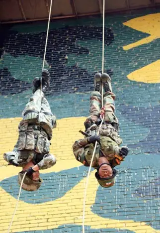  ??  ?? A Chinese soldier and an Indian soldier dropping down from cables during a joint counter-terrorism exercise by the two countries in Kunming, Yunnan Province