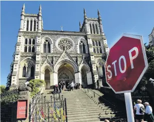  ?? PHOTO: STEPHEN JAQUIERY ?? It must stop . . . Abuse survivors, their supporters and representa­tives of the Catholic Diocese of Dunedin gather to tie ribbons of remembranc­e to the gates of St Joseph’s Cathedral yesterday.