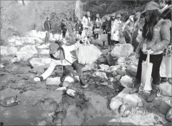  ?? YUAN JINGZHI / FOR CHINA DAILY ?? More than 300 volunteers from colleges in Xi’an, Shaanxi province, picked up garbage on Tuesday as part of a campaign to protect the environmen­t of Qinling Mountain.