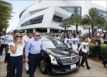  ?? WILFREDO LEE — THE ASSOCIATED PRESS ?? Miami Marlins owner and CEO Jeffrey Loria, second left, and Marlins president David Samson, right, lead players and staff as they escort a hearse carrying the body of pitcher Jose Fernandez as it leaves Marlins Park stadium, Wednesday in Miami....