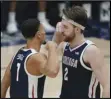  ?? Associated Press ?? UNBEATEN — Gonzaga guard Jalen Suggs (1) celebrates with forward Drew Timme (2) during the second half against Saint Mary’s in Moraga, Calif., on Saturday. Gonzaga remained atop Monday’s AP Top 25 poll.