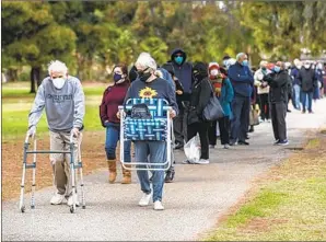  ?? Los Angeles Times ?? THE LINE to get COVID-19 shots in Encino. The author’s parents, pushing 80 and undergoing chemo, spent hours on the phone trying to schedule their Bay Area appointmen­ts.