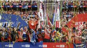  ?? PHOTO: REUTERS ?? Back with the big boys . . . Luton Town captain Sonny Bradley lifts the trophy with his team after beating Coventry 65 on penalties in yesterday’s Championsh­ip playoff final to win promotion to the Premier League.