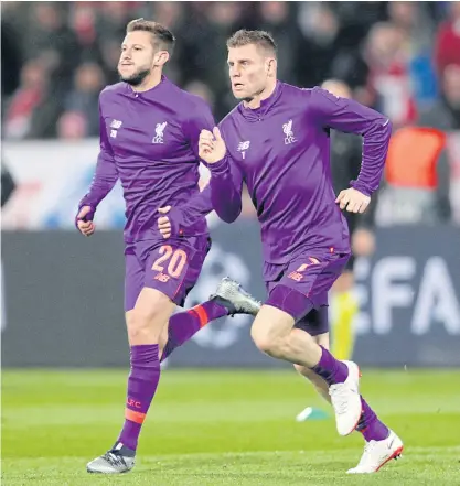  ??  ?? Liverpool’s Adam Lallana, left, and James Milner warm up before the match against Red Star Belgrade.