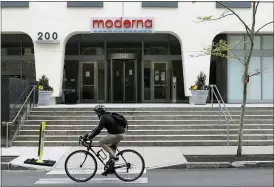  ?? BILL SIKES — THE ASSOCIATED PRESS FILE ?? A bicyclist pedals past an entrance to a Moderna, Inc., building May 18in Cambridge, Mass.