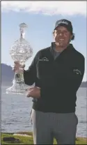  ?? The Associated Press ?? PEBBLE NO. 5: Phil Mickelson poses with his trophy Monday on the 18th green of the Pebble Beach Golf Links after winning the AT&amp;T Pebble Beach Pro-Am golf in Pebble Beach, Calif.