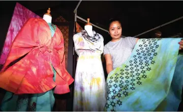  ??  ?? Lyona Stephen shows a few samples of ‘linut batik’ fabrics with different motifs. — Bernama photos