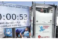  ??  ?? Medienrumm­el um den Mann im Eis: Nur mit einer Badehose bekleidet steigt der 42-jährige Josef Köberl in die Glasbox. Als im das Eis bis zu den Schultern reicht, läuft die Zeit