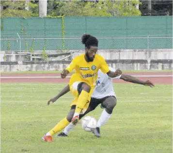  ?? (Photo: Paul Reid) ?? Vere United’s Lamar Neil (foreground) tries to turn away from Cavalier FC’S Lamounth in Sunday’s JPL game at the Montego Bay Sports Complex. The game ended 0-0.