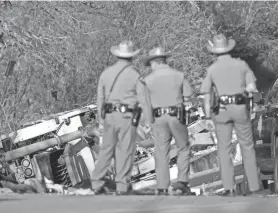  ?? JAY JANNER/AMERICAN-STATESMAN ?? State troopers look at a vehicle that was involved in a fatal school bus crash on SH 21 near Caldwell Road on March 22.