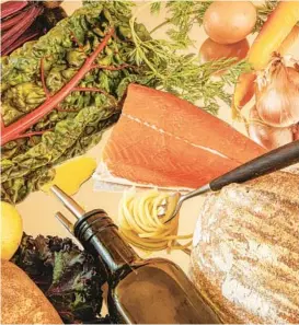  ?? LAUREN SEGAL/THE NEW YORK TIMES ?? Staples of the Mediterran­ean diet include whole grains, root vegetables, olive oil, hummus, leafy greens and fish rich in omega-3 fatty acids like salmon.