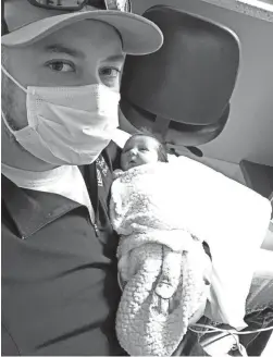  ?? PHOTOS BY TARYN MEINHOLZ ?? Derek Townsend holds his newborn daughter Lucy Kyu Townsend.