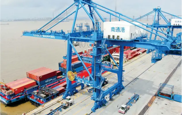  ?? Associated Press ?? Containers are being loaded onto a ship at Nantong Port, China.