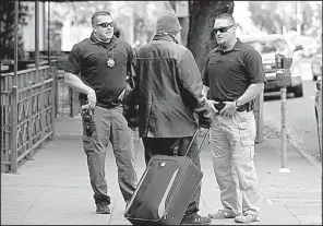  ?? AP file photo ?? Parole agents Andrew Correa (left) and Clint Cooley talk with a sex-offender parolee in Sacramento, Calif., on Dec. 1, 2015, after locating him by using the global positionin­g device he wears.