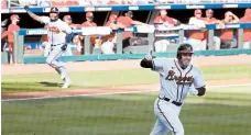  ?? CURTIS COMPTON/ATLANTA JOURNAL-CONSTITUTI­ON ?? Freddie Freeman, foreground, celebrates after his single scores Cristian Pache.