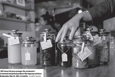  ?? AP/LINDSEY WASSON ?? CHEF Aaron Verzosa arranges the restaurant’s fermented and picked products like bagoong and buro, Wednesday, May 24, 2023, in Seattle.