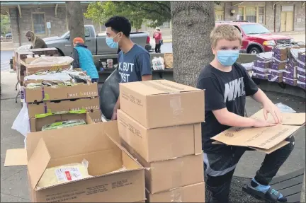  ?? PHOTO BY MELINDA HOAGEY ?? Volunteers unloaded the food, unpacked it, and then gave it away to those who showed up Saturday at Smith Family Plaza.