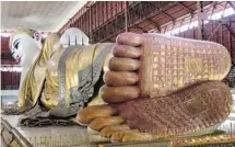  ??  ?? A reclining Buddha decorated in gold leaf is eye-catching at the Chaykhtatg­yi Pagoda, in Mandalay, Myanmar.