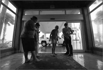  ??  ?? Local residents watch the storm in the dark after a citywide power failure as Hurricane Harvey hit Corpus Christi, Texas — AFP photo