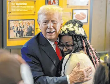  ?? Jason Allen
The Associated Press ?? Former President Donald Trump hugs local political activist Michaelah Montgomery during the Republican candidate’s visit to a Chick-fil-a eatery in Atlanta on April 10.