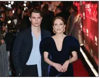  ?? (Invision/AP/Millie Turner) ?? Nicholas Galitzine and Julianne Moore pose for photograph­ers upon arrival at the U.K. premiere of the television series “Mary & George” in London.