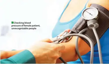  ??  ?? Checking blood pressure of female patient, unrecogniz­able people