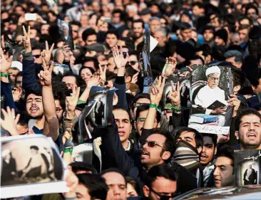  ?? — AP / Reuters ?? Passing of an icon: Mourners chant slogans while flashing the victory sign, referring to the success of moderates and reformists in recent elections, during the funeral of Rafsanjani. Below: Rouhani paying his last respects during a mourning ceremony...