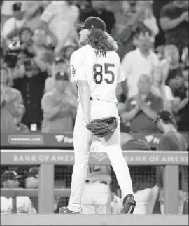  ?? Mark J. Terrill Associated Press ?? DODGERS starting pitcher Dustin May walks off to a standing ovation after finishing his major league debut. He allowed three earned runs in 52⁄3 innings.