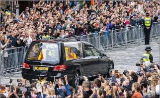  ?? JANE BARLOW — POOL PHOTO VIA AP ?? The hearse carrying the coffin of Queen Elizabeth II, draped with the Royal Standard of Scotland, passes the City Chambers on the Royal Mile, Edinburgh, Sunday. The Queen died Thursday at age 96.