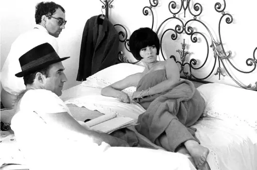  ?? BILD: imago ?? Dreharbeit­en zu „Die Verachtung“: Regisseur Jean-Luc Godard (hinten) mit Michel Piccoli und Brigitte Bardot (1963)
