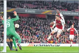  ??  ?? Arsenal's Danny Welbeck (R-top) scores the team's third goal against AC Milan during the UEFA Europa League round of 16 second-leg football match.