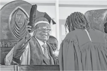  ?? Ben Curtis / Associated Press ?? In his first public appearance Friday since the military put him under house arrest this week. Zimbabwe President Robert Mugabe, left, presides over a graduation ceremony at Zimbabwe Open University.