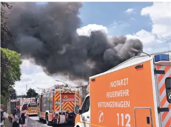  ?? FOTO: SASCHA RIXKENS ?? Die Rauchsäule stieg über dem brennenden Müllberg an der Boetgerstr­aße auf. Drei Wachen der Berufsfeue­rwehr und beinahe alle Einheiten der freiwillig­en Feuerwehr waren im Einsatz.