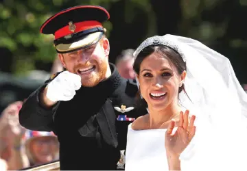  ?? — Reuters file photo ?? Prince Harry gestures next to his wife Meghan as they ride a horse-drawn carriage after their wedding ceremony at St George’s Chapel in Windsor Castle in Windsor, Britain, last May 19.