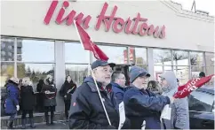  ?? CHRIS YOUNG / THE CANADIAN PRESS ?? Members of Ontario Federation of Labour protest outside a Tim Hortons franchise in Toronto last week.