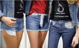  ??  ?? LAS VEGAS: Models wear jeans from Spinali Designs at CES Internatio­nal on Friday in Las Vegas. The $100 jeans will vibrate on your right or left hip to let you know which direction you should head. —AP