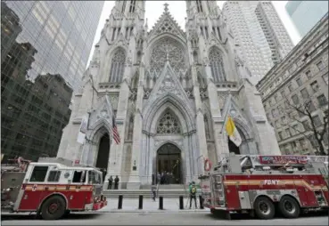  ?? SETH WENIG — THE ASSOCIATED PRESS ?? While firemen conduct an inspection, fire trucks are parked in front of St. Patrick’s Cathedral in New York, Thursday. A New Jersey man was arrested Wednesday night, after entering the cathedral carrying two cans of gasoline, lighter fluid and butane lighters, the New York Police Department said, just days after flames ravaged the Notre Dame cathedral in Paris.