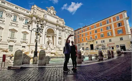  ?? ANDREW MEDICHINI/AP ?? PANCURAN SEPI: Sepasang wisatawan berswafoto di Fontana di Trevi, Roma, kemarin. Biasanya, tempat tersebut penuh turis dari berbagai penjuru dunia.