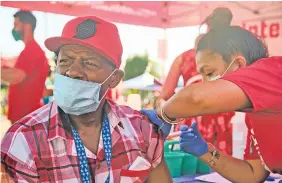  ?? TOJO ANDRIANARI­VO/THE NEW YORK TIMES ?? A person receives a dose of a COVID-19 vaccine Thursday near Portland, Ore. The U.S. vaccine rollout has plateaued and the course of the coronaviru­s pandemic in this country may depend on how many people are ultimately swayed to get vaccinated.