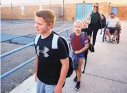  ??  ?? Arriving before Monday’s first day of classes at Mitchell Elementary School are, front to back, Brodie Burton, 10, Mackinzie Burton, 8, Logan Burton, 6, mother Cassie Burton and her friend Josh Rogers.