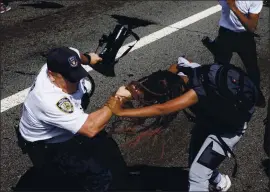  ?? YUKI IWAMURA — THE ASSOCIATED PRESS ?? A Black Lives Matter protester’s hair is pulled by an NYPD officer as they scuffle during a demonstrat­ion on the Brooklyn Bridge in New York on Wednesday.