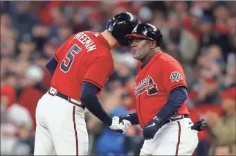  ?? Brett davis/usa Today sports ?? Atlanta Braves first baseman Freddie Freeman celebrates a single with first base coach Eric Young Sr. against the Houston Astros during the third inning during game three of the 2021 World Series at Truist Park.