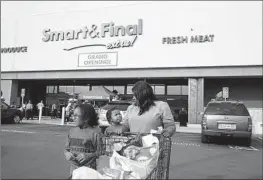  ?? Dania Maxwell Los Angeles Times ?? “DISCRIMINA­TION goes against our core values and has no place in our stores,” Smart & Final said in a statement. Above, a family leaves a store in Watts in 2020.