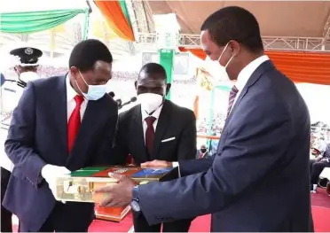  ??  ?? Former President Edgar Lungu (right) hands over the instrument­s of power to President Hakainde Hichilema